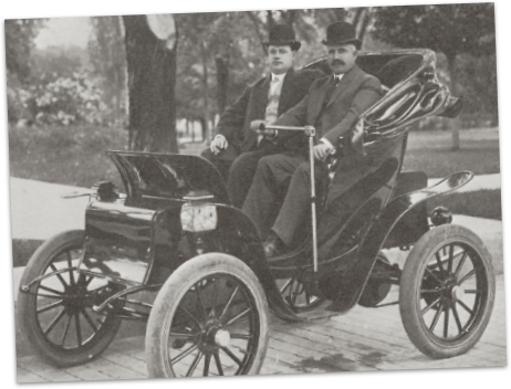 Well dress men in an early car