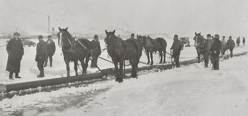 Men and horses putting in a pipeline in the snow