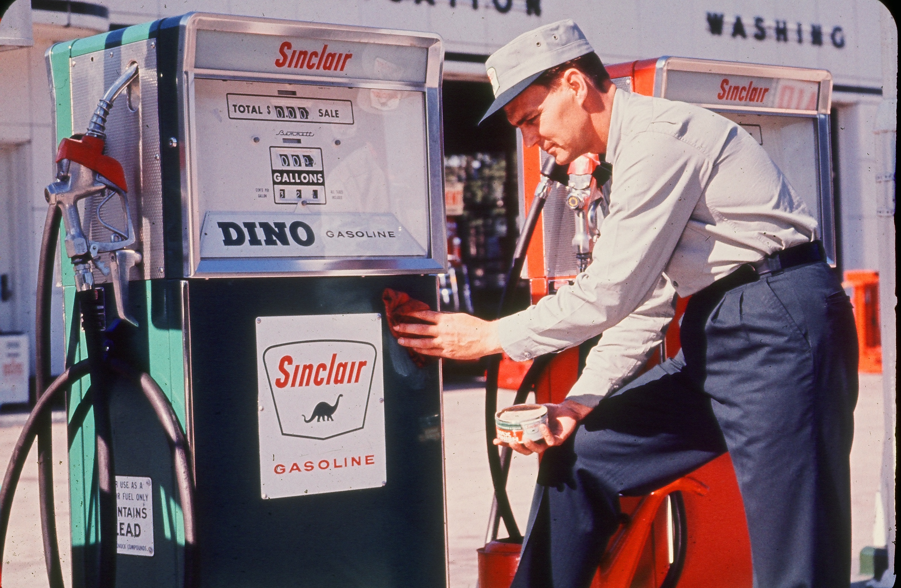 Sinclair oil gas station attendant cleaning a gas pump