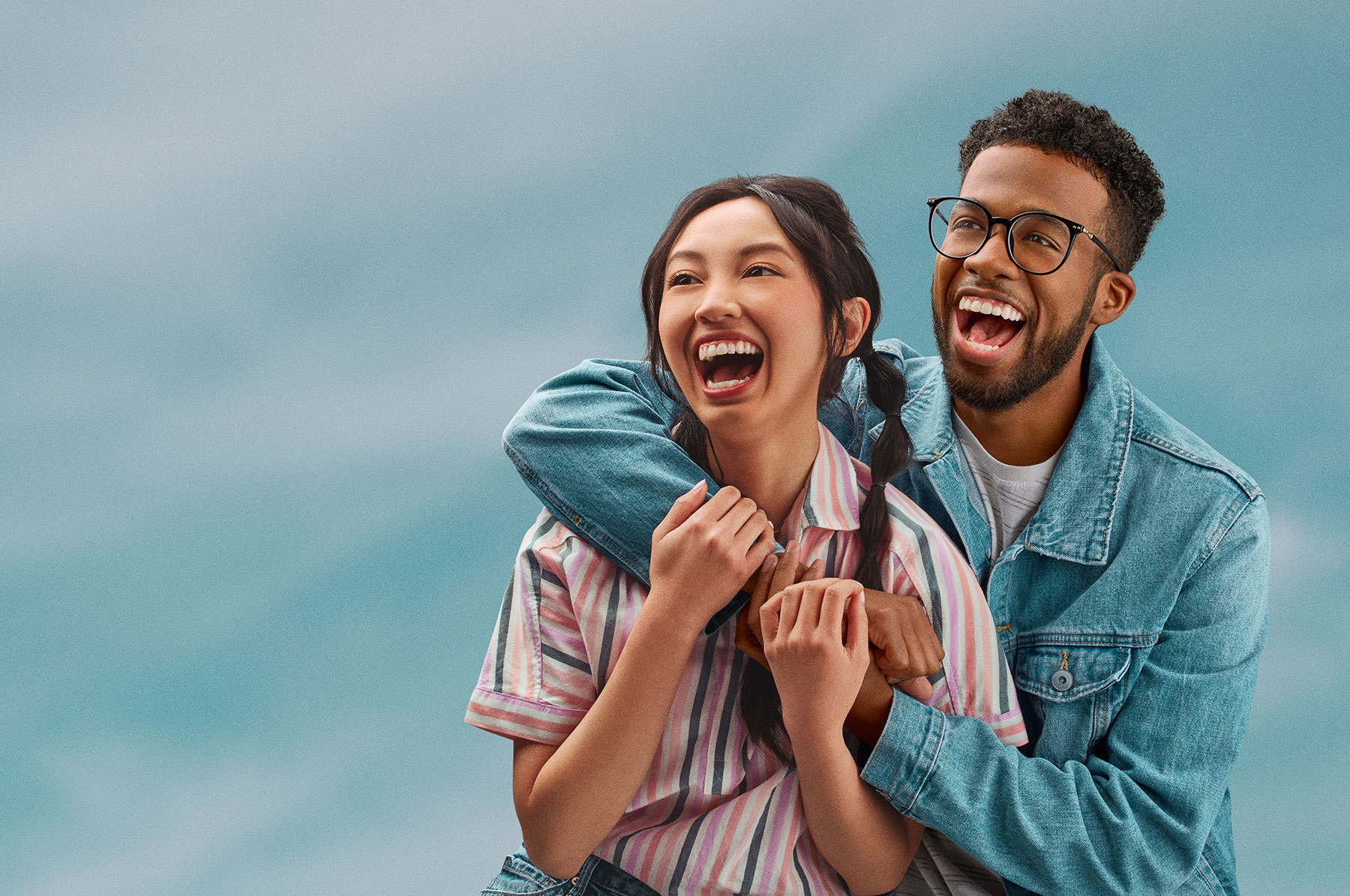 Couple hugging with sky background behind them