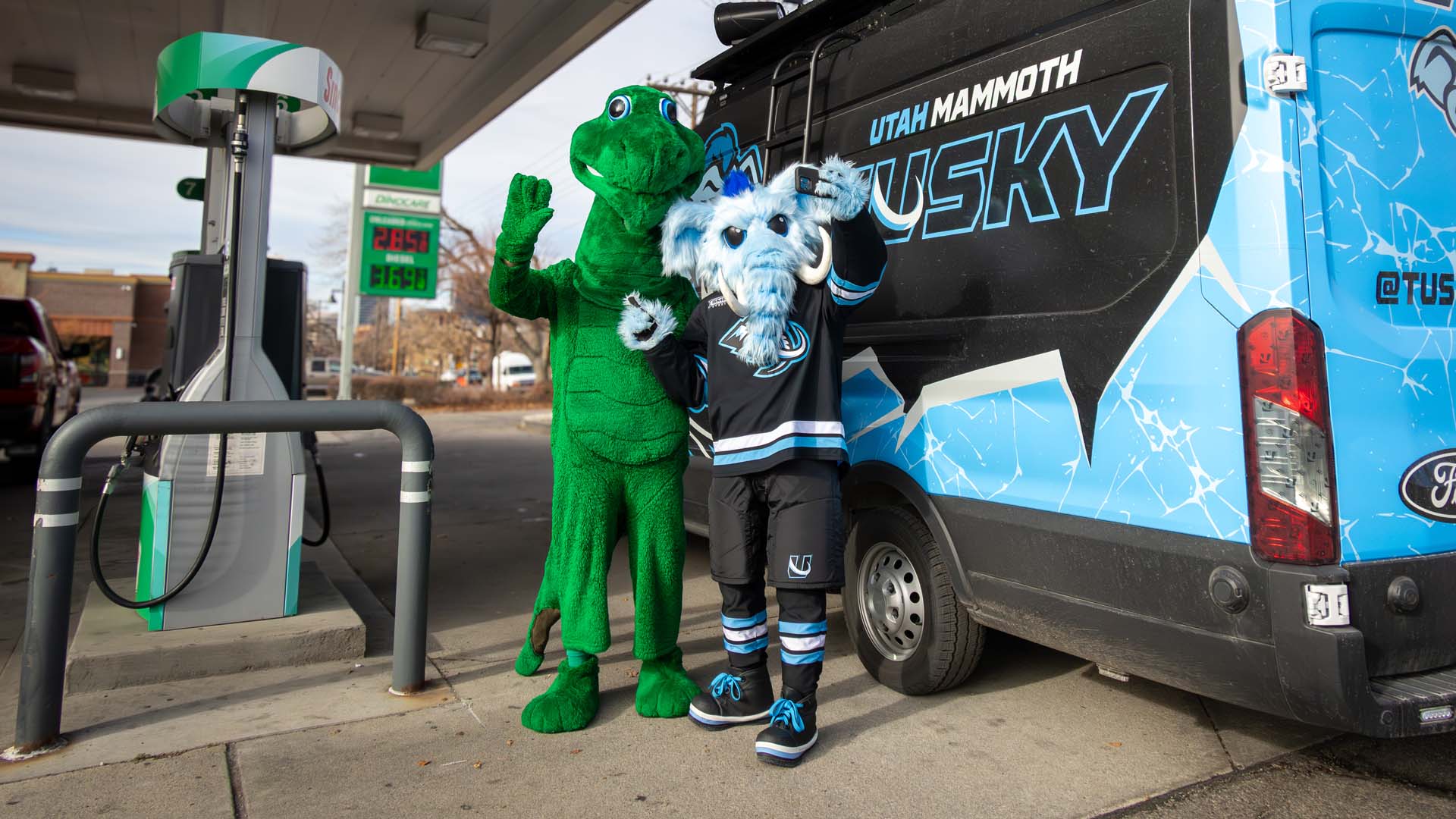 Dino and Tusky waving in front of Tusky's truck
