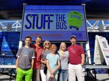 group of people in front of Stuff the bus sign